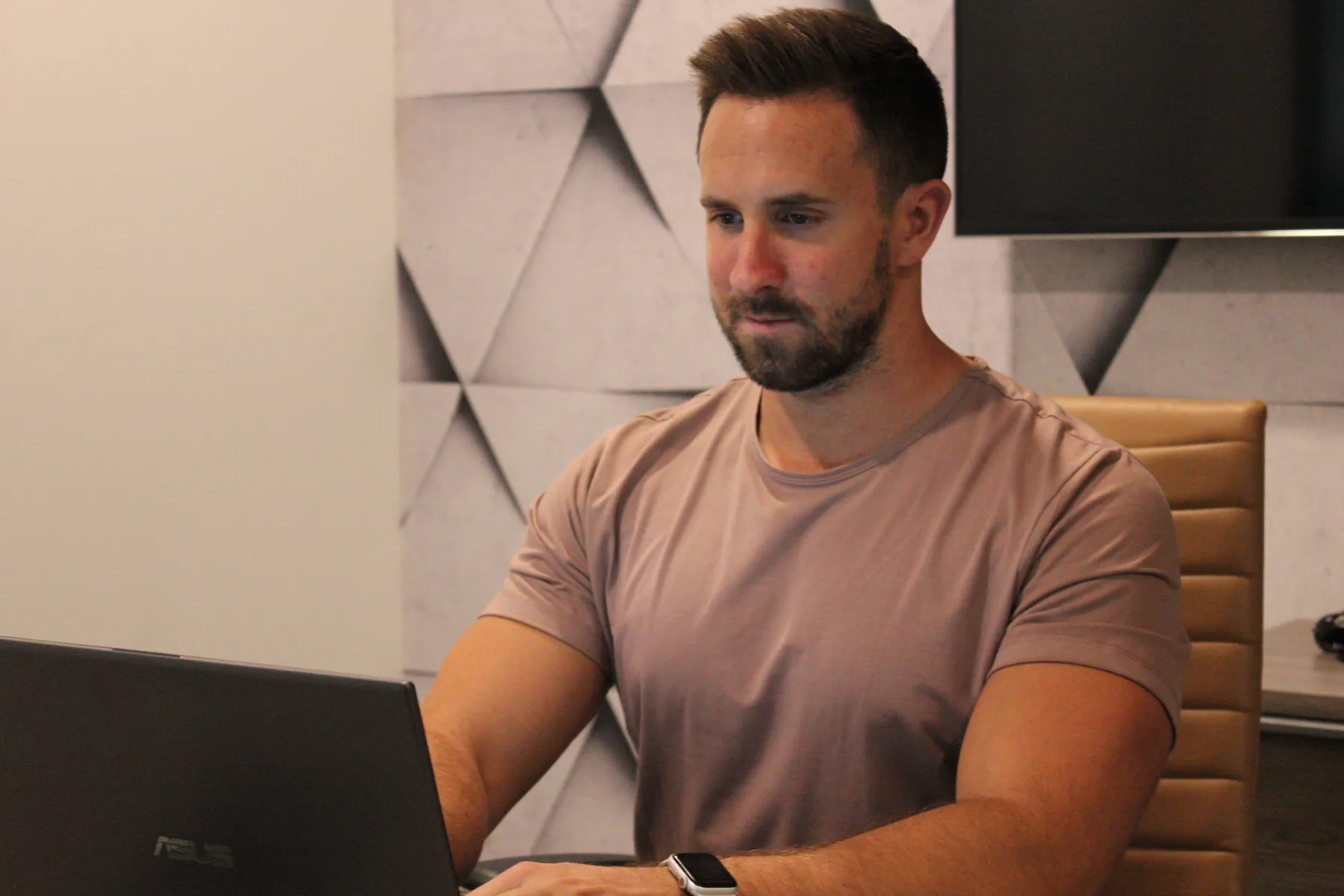 Tyler working with a client program on a laptop